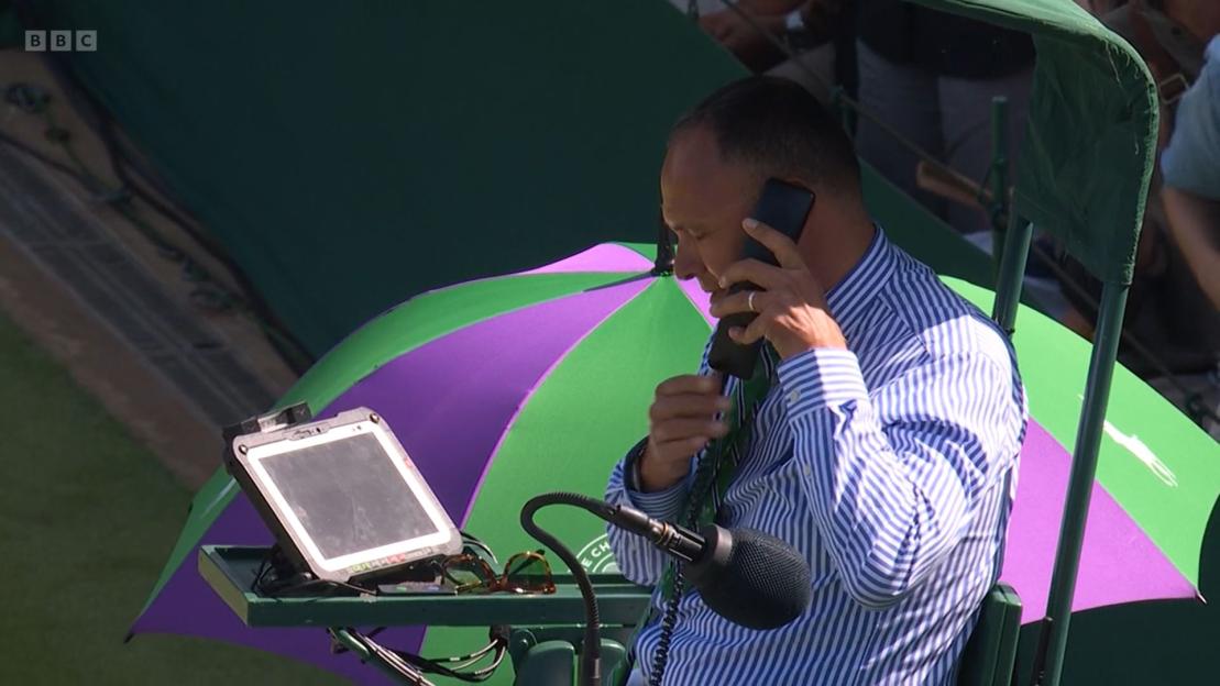 BBC commentator on the phone at Wimbledon.