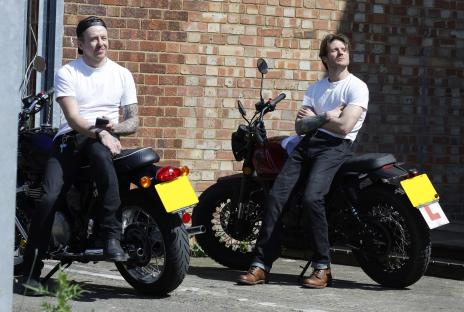 Two men sitting on motorcycles.
