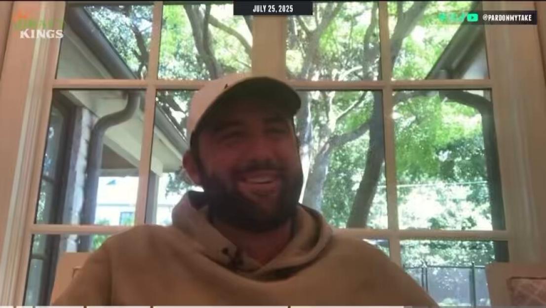 Man smiling in front of a window.