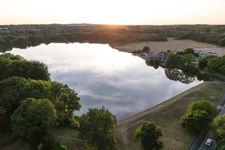 Aerial view of a lake in a park with rescue teams searching for a missing teenager.