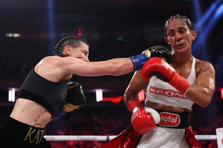 Katie Taylor throwing a punch at Amanda Serrano during a boxing match.