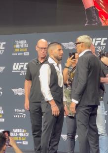 Two UFC fighters facing each other at a press conference.