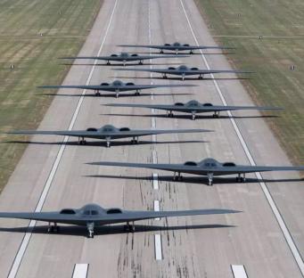 Line of B-2 stealth bombers on a runway.