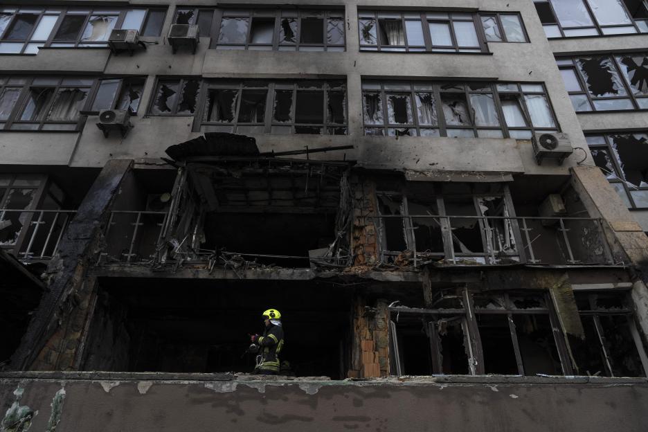 Firefighter at fire-damaged residential building.