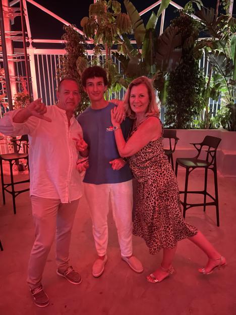 Three people posing for a photo at a nightclub.
