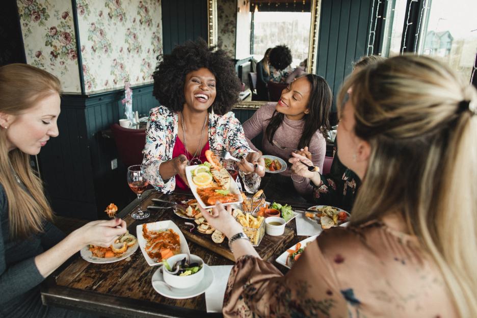 Group of women sharing a meal at a restaurant.