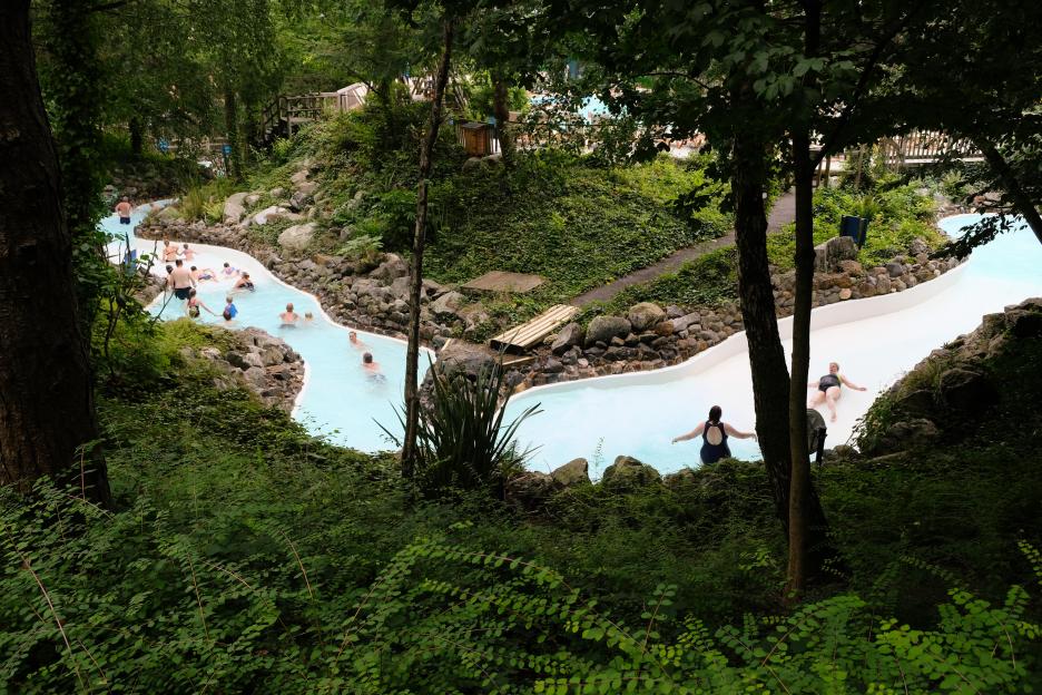 Swimmers enjoying a lazy river at an outdoor pool.