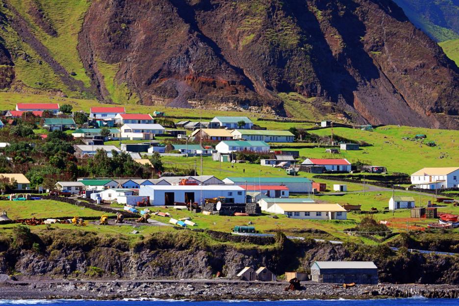 High-angle view of a small town nestled against a steep, rocky hillside.