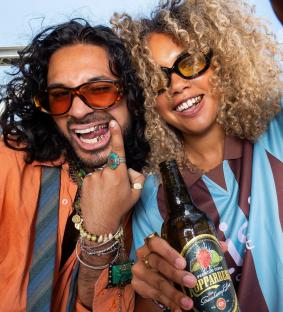Two people smiling for a selfie, one holding a bottle of Kopparberg Strawberry & Lime cider.