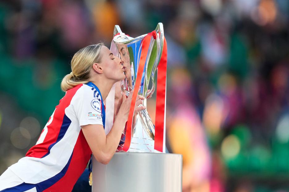 Chloe Kelly kissing the UEFA Women's Champions League trophy.