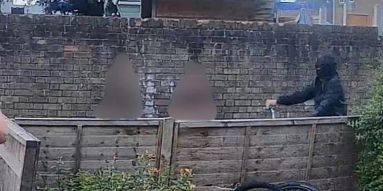 CCTV image of a masked person on an electric motorcycle.