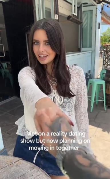 Woman announcing she and her partner are moving in together after meeting on a reality dating show.