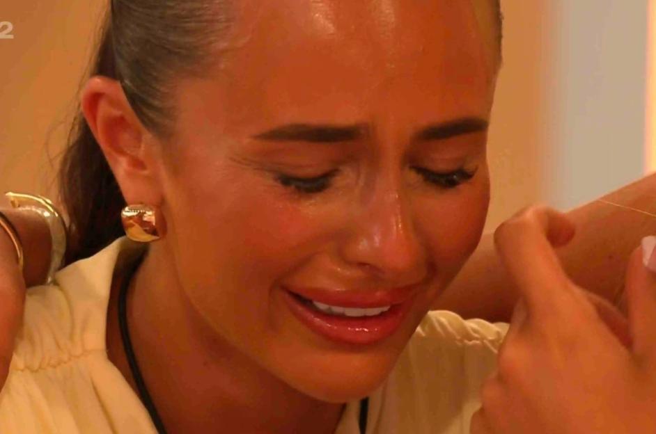 A woman crying comforted by another woman.