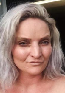 Close-up portrait of a woman with shoulder-length, light gray hair.