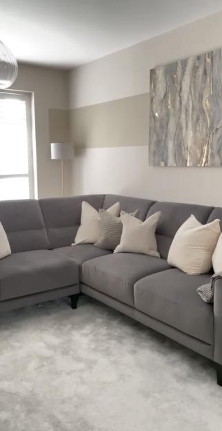 Grey sectional sofa with pillows in a living room.