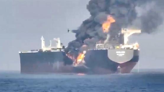 A large oil tanker engulfed in flames at sea.
