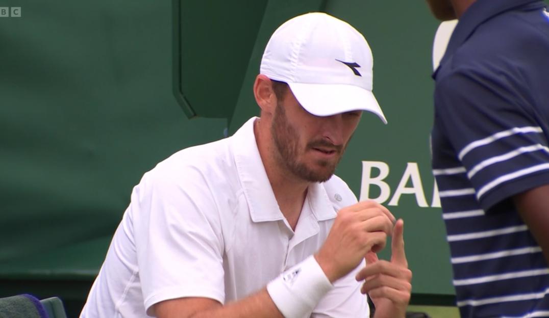 Tennis player adjusting his wristband.