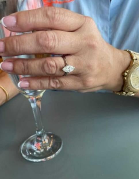 Close-up of a hand showing off an engagement ring.