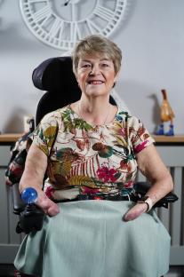 Portrait of a smiling woman in a wheelchair.
