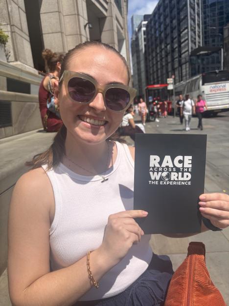 Woman holding Race Across the World experience pamphlet.