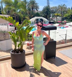 Woman in a knit maxi dress by a resort pool.