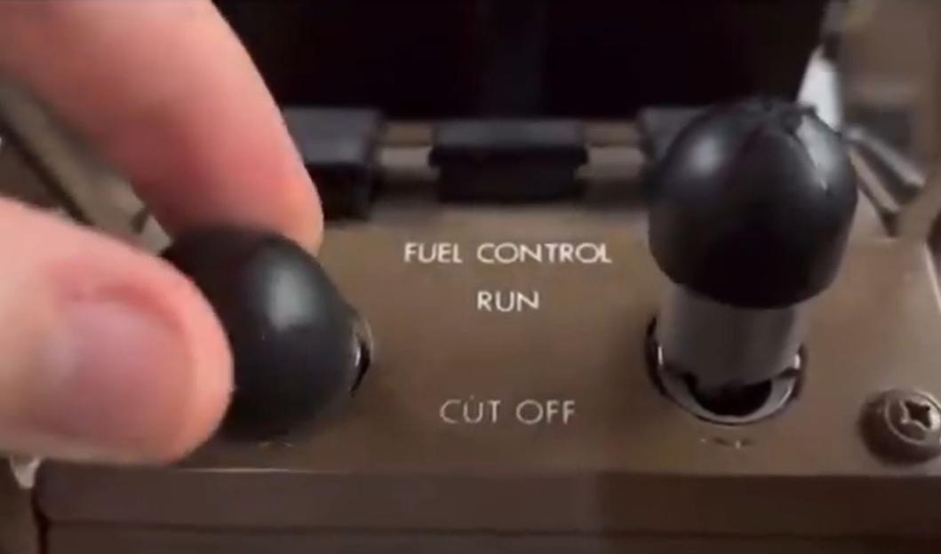 Hand operating a fuel control switch.