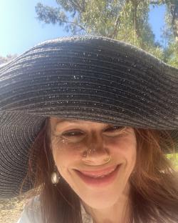Fairuza Balk wearing a large sun hat.