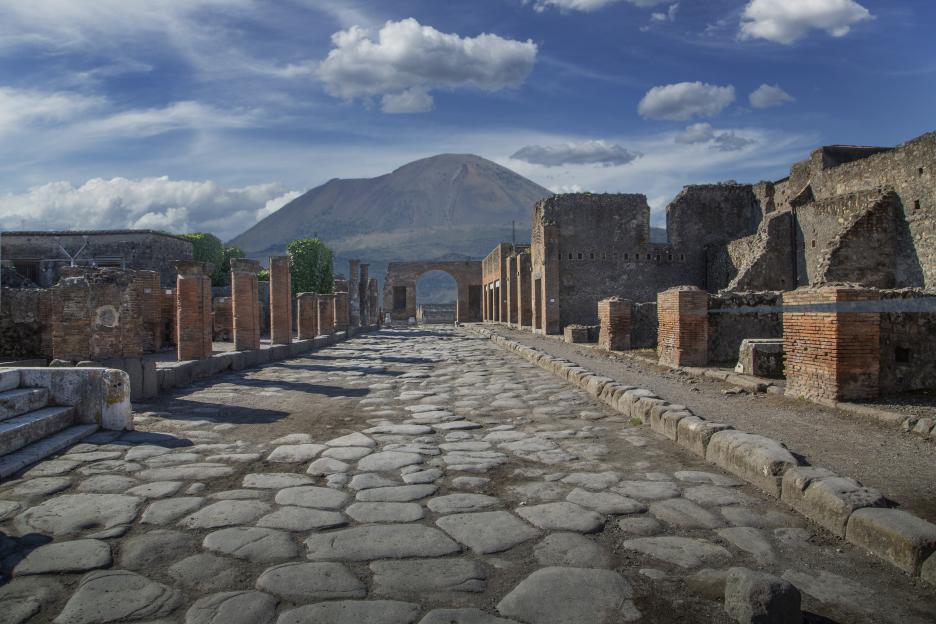 Ancient Roman ruins in Pompeii with Mount Vesuvius in the background.