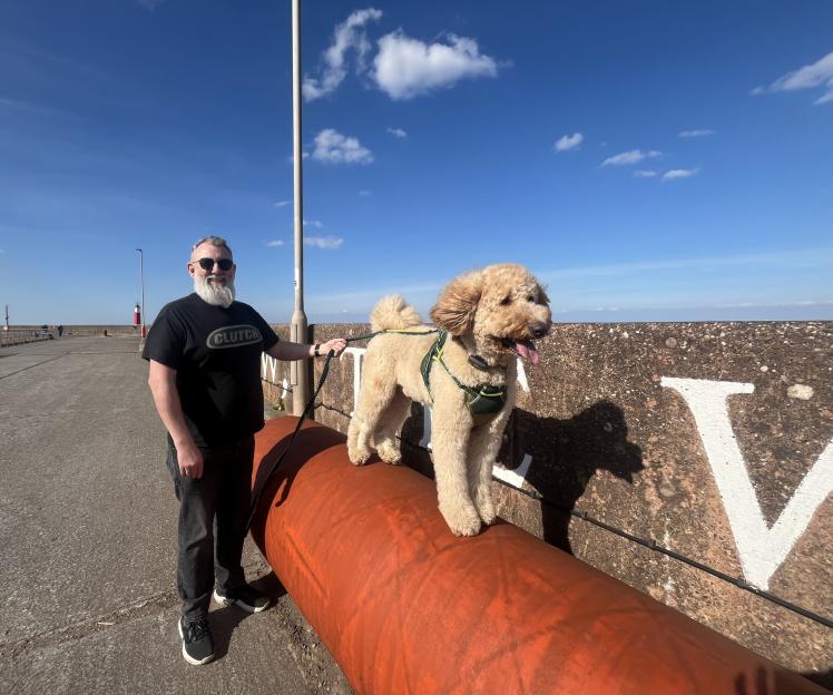 A man and his large dog on a sunny day.