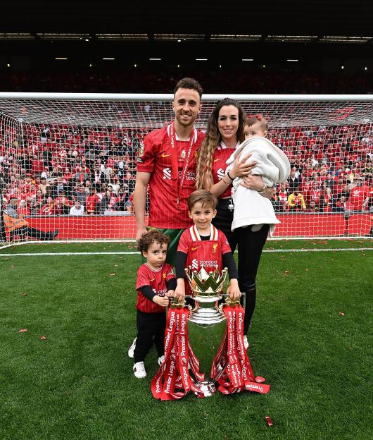 Family photo of Diogo Jota with his family and the Premier League trophy.