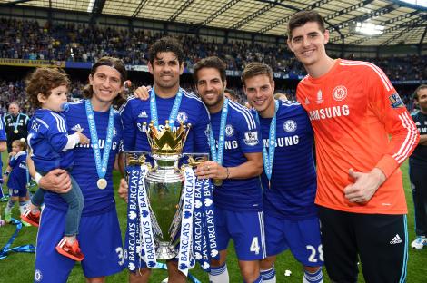 Chelsea F.C. players celebrating with the Premier League trophy.