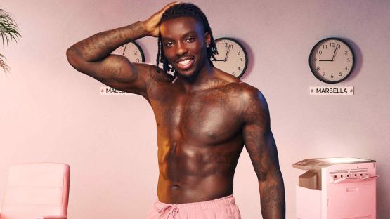 Portrait of a shirtless man in pink shorts.