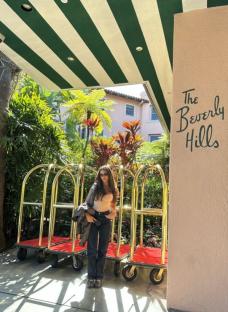 Woman standing in front of The Beverly Hills hotel.