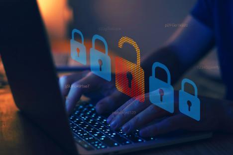 Person typing on laptop with unlocked padlock icon and other locked padlocks.