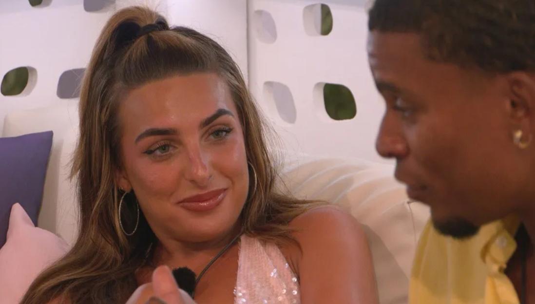Screenshot of a young woman and man talking.