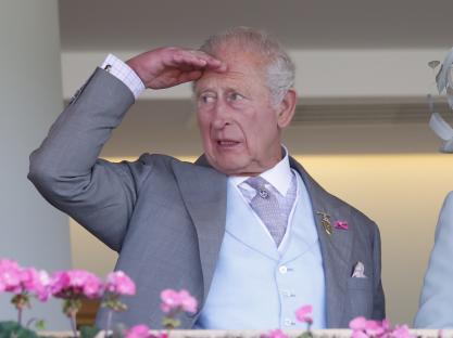 King Charles III shielding his eyes at Royal Ascot.