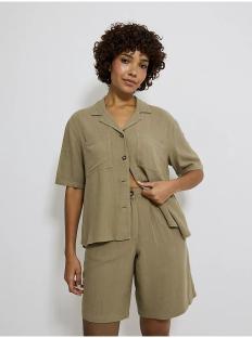 Model wearing a sage green linen short-sleeved button-up shirt and matching shorts.
