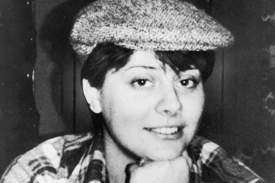 a black and white photo of a woman wearing a hat