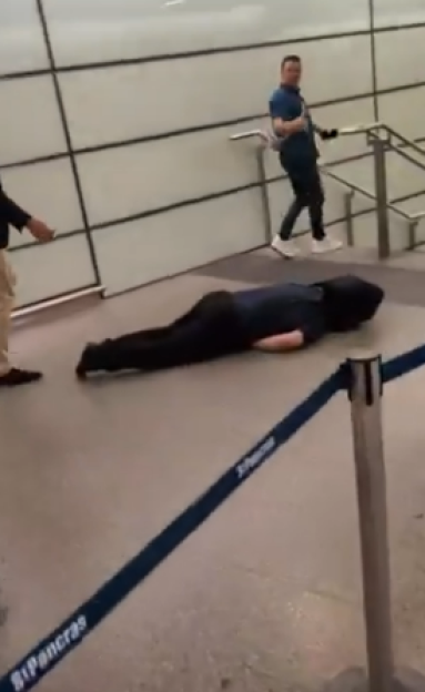 Man lying unconscious on the floor of St Pancras International station.