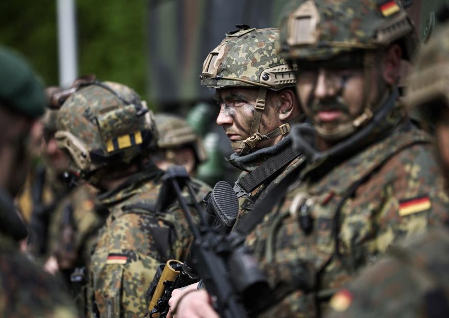 German soldiers in camouflage uniforms and helmets.