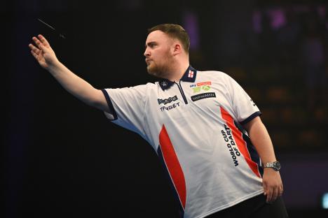 Luke Littler of England throwing a dart during a darts match.