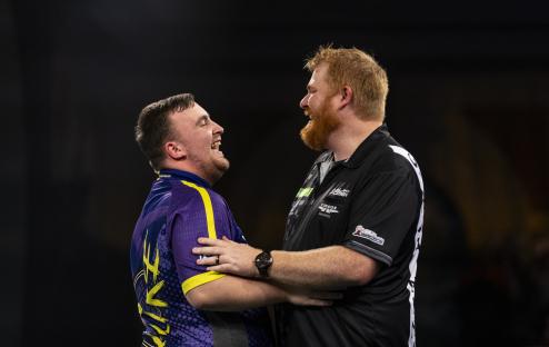 Two darts players shaking hands after a match.