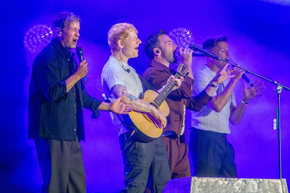 Ed Sheeran and Westlife performing on stage together.