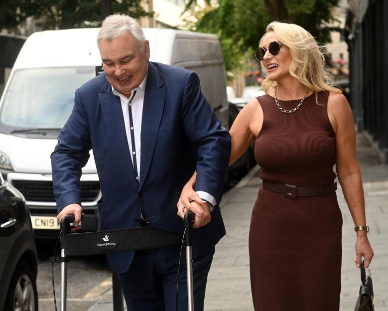 Eamonn Holmes and Katie Alexander walking together, he is using a walking aid.