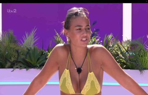 A woman in a yellow bikini top speaks.