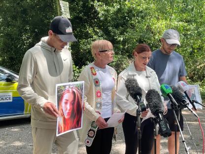 Relatives of a missing woman appeal for information at a press conference.