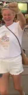 Woman wearing a white shirt and white shorts celebrating.