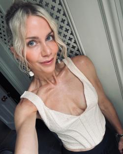 Woman in a white top and gold jewelry.
