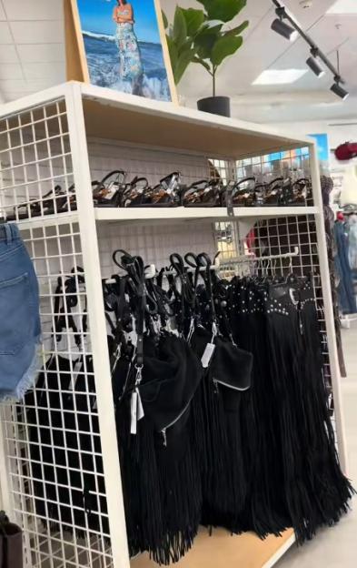 Primark display of black fringed bags and sandals.