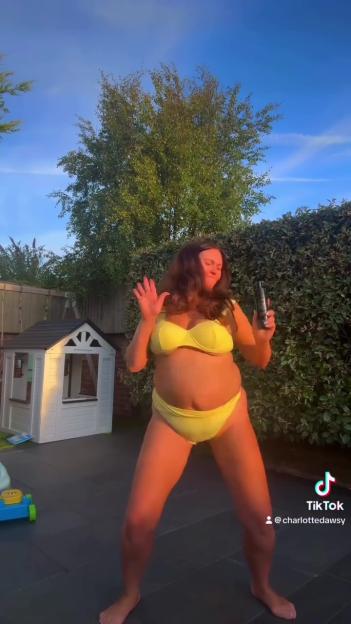 Woman in yellow bikini holding tanning product.
